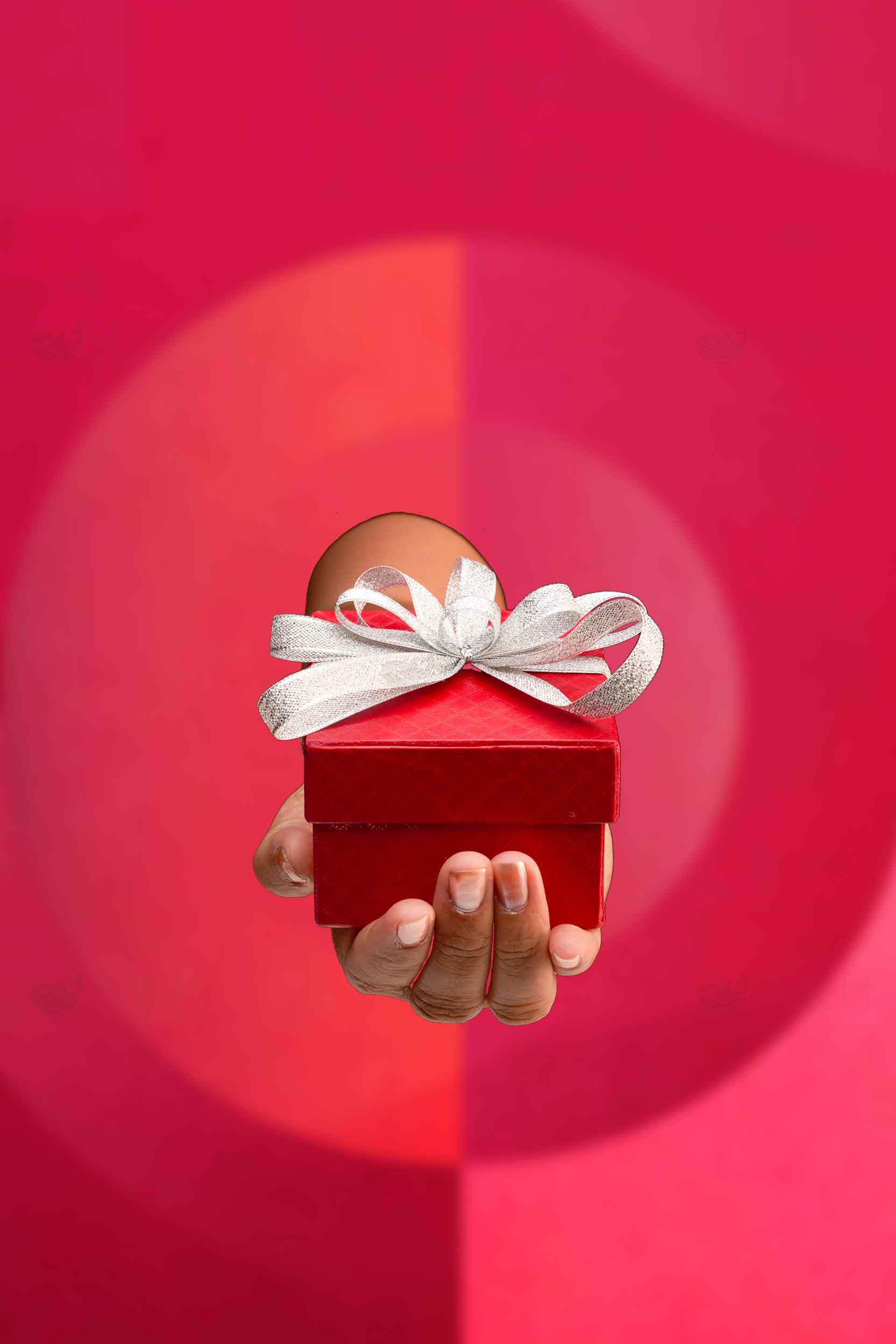 红色礼物盒手持图片——节日礼物创意设计素材